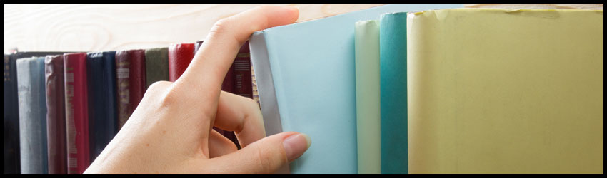 Hand grabbing a book from a shelf