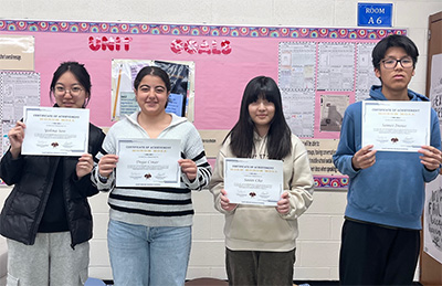 Four students holding awards